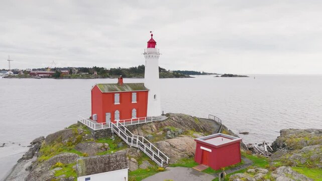 Victoria, British Columbia, Canada. November 02, 2024: Aerial view of the iconic Fisgard Lighthouse on Vancouver Island, surrounded by rocky shores and the vast ocean under a cloudy sky
