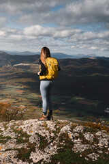 Naklejka premium Young woman tourism in nature with a mountain landscape, contemplating the views from a mountain in Euskadi