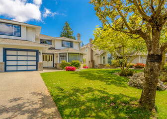 Two story stucco luxury house with nice summer  landscape in Vancouver, Canada, North America. Day time on June 2024.