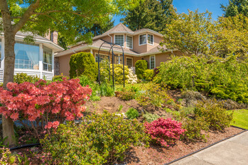 Two story stucco luxury house with nice summer  landscape in Vancouver, Canada, North America. Day time on June 2024.