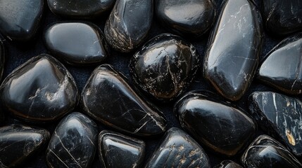 Smooth black river stones arranged in an artistic pattern showcasing their natural textures and colors ideal for home decor or landscaping.