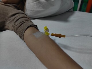 Arm with infusion with intravenous saline drip. Intravenous set saline drip on patient hand in the...