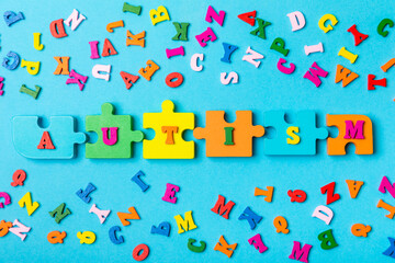 Autism awareness day.2 April world autism awareness day background.Design element.Care Awareness campaign for Autism.AUTISM text with colorful wooden puzzles, letters and cubes.Space for text.Top view