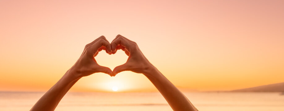 Hand making heart shape on beautiful sunset background. kindness love nature concept 
