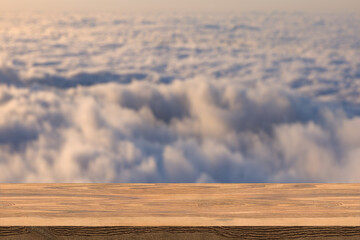 The blur cool cloud background with wood floor foreground on horizon tropical sandy beach relaxing outdoors vacation with heavenly mind view at a resort deck touching sunshine, sky surf summer clouds.