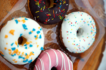 A selection of freshly baked donuts in multi-colored glaze. Beautiful sweet donuts with sprinkles....
