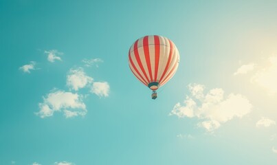 Fototapeta premium A vibrant hot air balloon floats against a clear blue sky, illuminated by sunlight, creating a serene and uplifting scene.