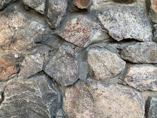 An old, weathered stone wall with irregular shapes and varying rock types is visible in the image The structure shows signs of age with cracks and eroded mortar The image provides a 3D representati