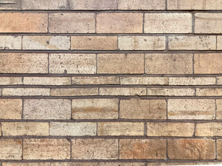 Close-up view of old, weathered brick wall made from concrete or similar material Bricks have slight color variation within rows, and the image focuses on texture without additional context