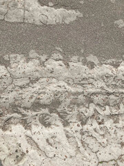 Close-up view of old, weathered road section with rough texture and cracks Gray color palette suggests urban setting No visible texts or artistic effects