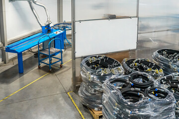 Hose cutting machine and ready-to-ship high pressure hose packages in production. High pressure...