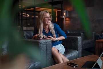 Happy Businesswoman Relaxing on a Sofa in a Modern Office