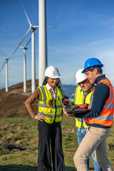 multiethnic Engineers working with laptop in wind turbine power plant