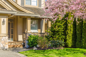 Entrance of grey painted luxury house in summer with stair steps and nice landscape in Vancouver, Canada, North America. Day time on June 2024.