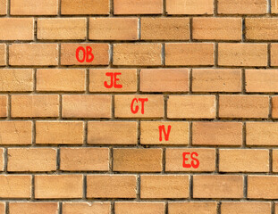 Objectives symbol. Concept word Objectives on beautiful brown bricks. Beautiful brown brick wall background. Business objectives concept. Copy space.