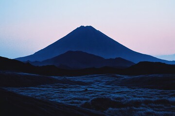 Fototapeta premium 山々のシルエットが美しい夕暮れの風景と静寂な大地の上の光の変化