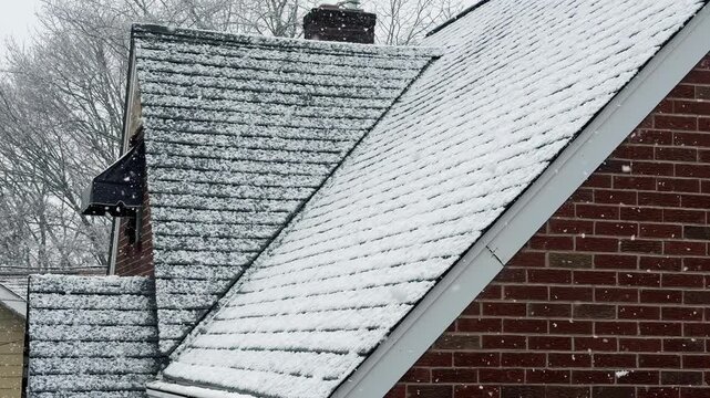 A slow-motion tilt down to a typical cape cod style red brick home during a heavy snow. Shot at 60fps.  	