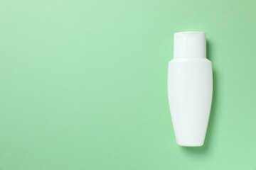 Cosmetic bottle on color background, top view