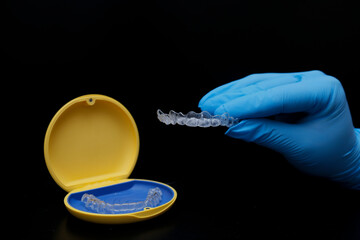 Orthodontic treatment with clear aligners used by dental professionals to realign teeth. Restoration of teeth with clear aligner trays. Orthodontic specialty. © UniqDream