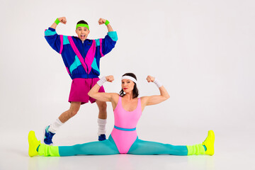 Energetic young couple in vibrant retro activewear demonstrating dynamic workout poses perfect for a fun fitness routine
