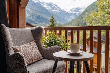 Fototapeta premium Cozy balcony with scenic mountain view and a cup of coffee in a peaceful afternoon setting. Generative AI