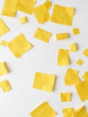 Several scattered pieces of vibrant yellow paper laying on a clean white background, offering ample copy space, template, mockup
