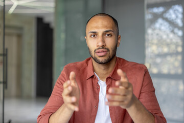 Casually dressed man using explained gestures while speaking, conveying communication and...