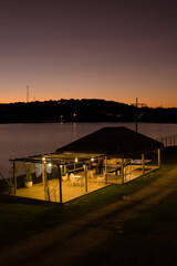 A small pavilion is lit up at night by a lighted lantern