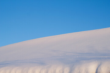 snow drift with blue sky in sunny winter day