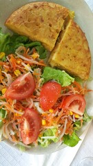 Close up do prato com torta de legumes com salada.