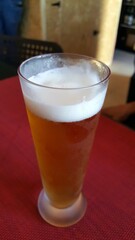 Um fino ou imperial, de portugal, sobre uma mesa vermelha.