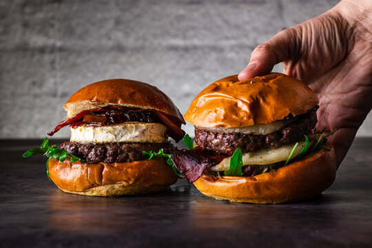 Delicious gourmet burgers with brie cheese on rustic table