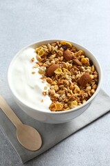 Delicious granola with yogurt on a light background