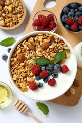 Delicious granola with berries and yogurt on a light background