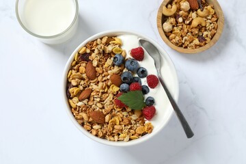 Delicious granola with berries and yogurt on a light background