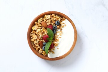 Delicious granola with berries and yogurt on a light background