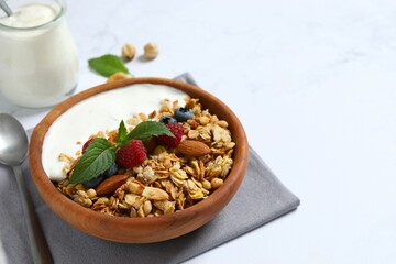 Delicious granola with berries and yogurt on a light background