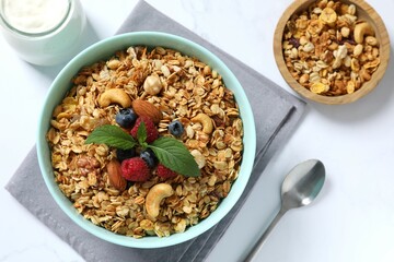 Delicious granola with berries and yogurt on a light background