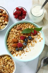 Delicious granola with berries and yogurt on a light background