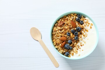 Delicious granola with berries and yogurt on a light background