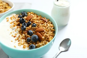 Delicious granola with berries and yogurt on a light background