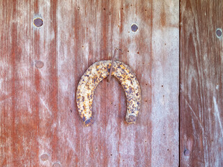 Weathered rusty horseshoe hanging on a nail on a very old wooden house door, isolated detail in the Bulgarian Fore-Balkan village of Debnevo, Troyan Municipality, selective focus 