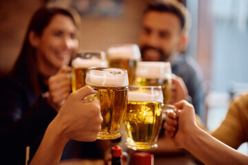 Close up of people toasting with beer glasses.