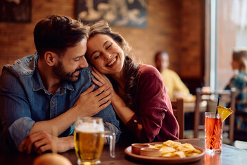 Young happy couple enjoying on date in pub.