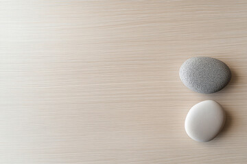 minimalist, photography, a balanced composition of three smooth stones on a light wooden surface