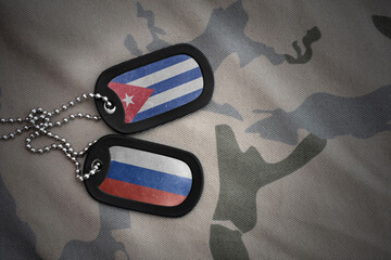 vintage army blank, dog tag with flag of cuba and russia on the khaki texture background. military...
