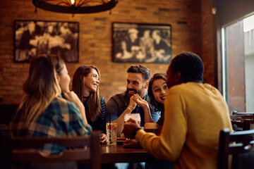 Multiracial group of happy friends gathering in pub.