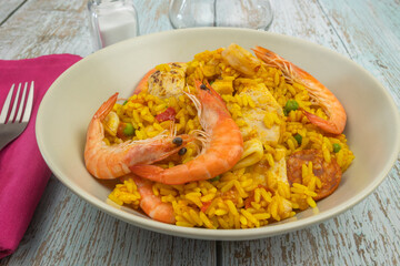 assiette de paella, en gros plan, sur une table en bois