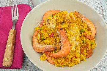assiette de paella, en gros plan, sur une table en bois