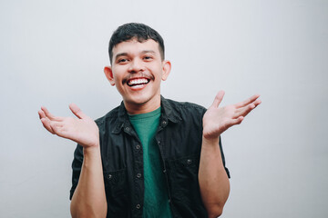 Happy Young Man Expressing Joy with Open Hands in a Simple Indoor Setting